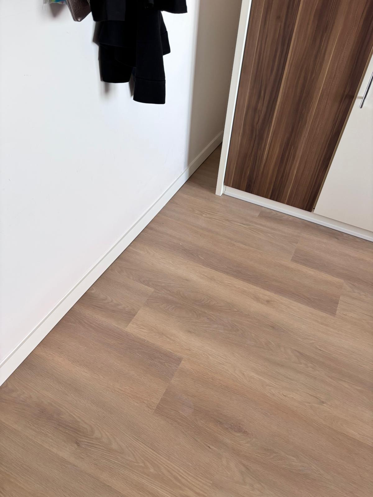Nieuw gelegde laminaatvloer met afgewerkte plinten